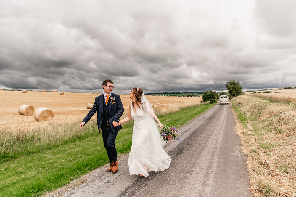 bride and groom running wellington barn cotswolds