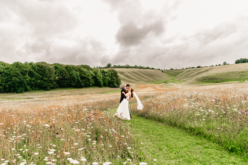 bride and groom running wellington barn wiltshire meadow