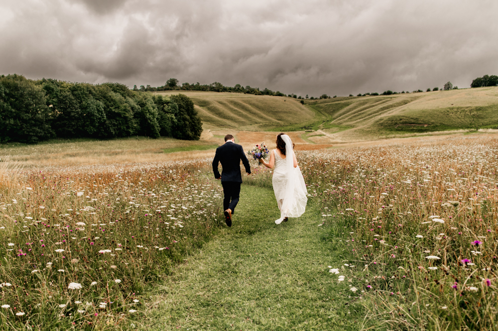 bride and groom running wellington barn wiltshire