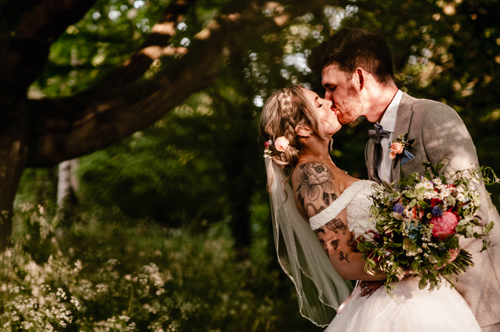 bride and groom kissing cotswolds