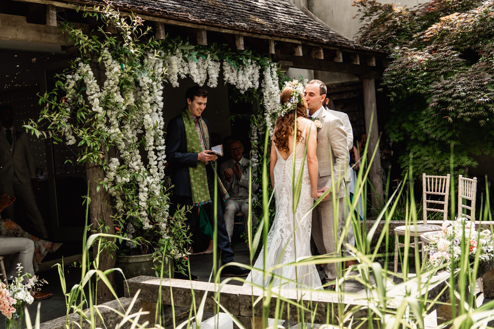 bride and groom first kiss outdoor garden wedding venue