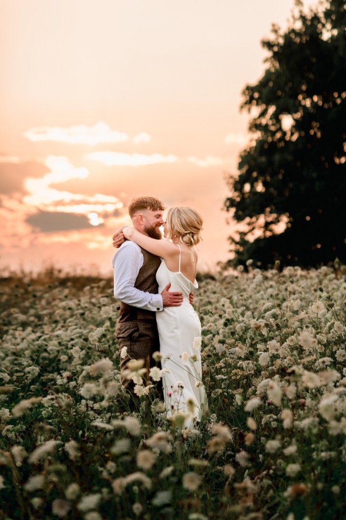 bride and groom in meadow sunset