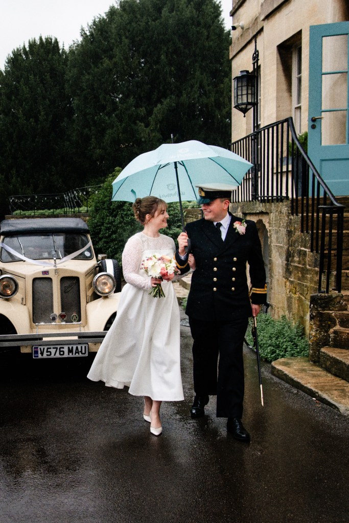 bride and groom under blue umbrella painswick