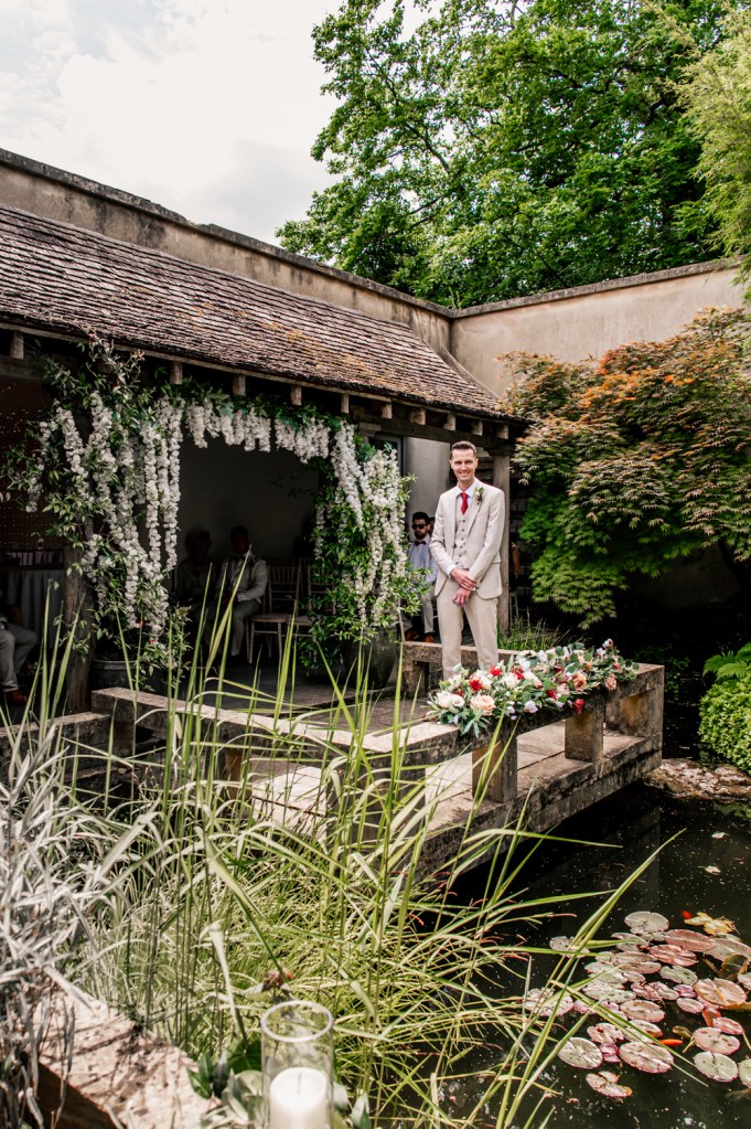 groom waiting for bride lush garden venue