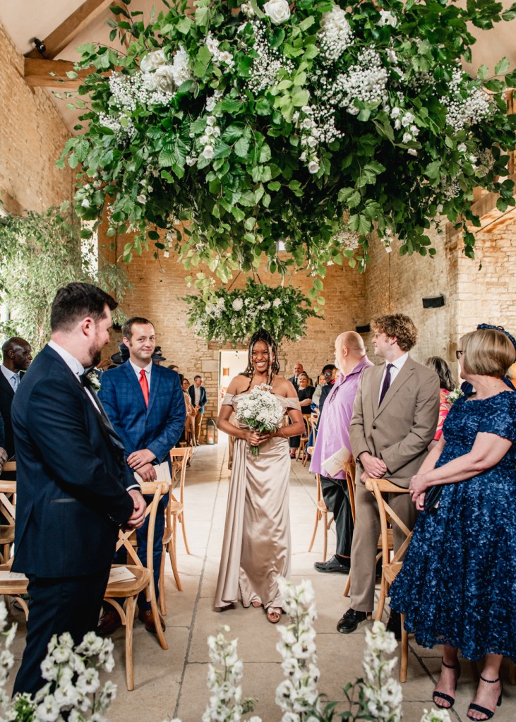 bridesmaid going down the aisle barn wedding