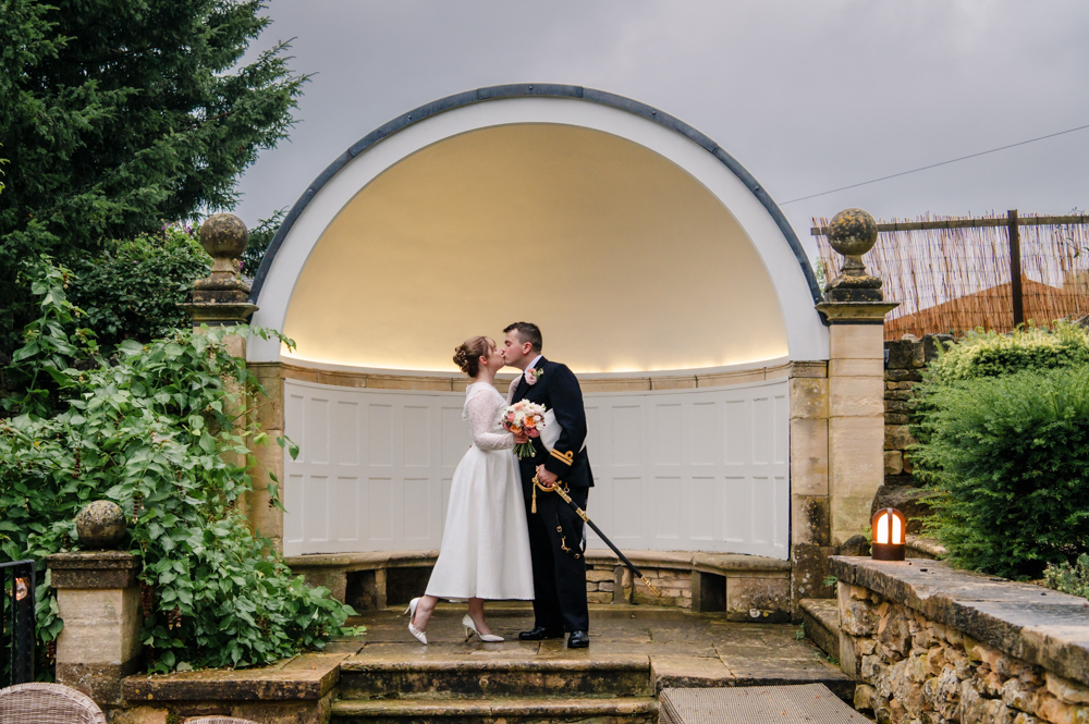 bride and groom under arch 