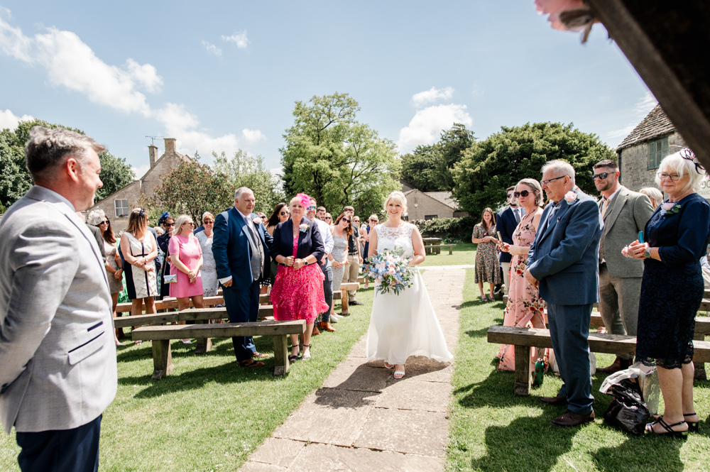 bride walking down aisle garden wedding