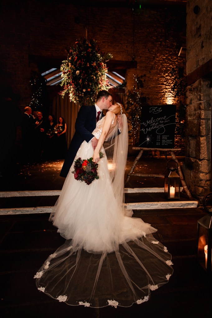 bride and groom kissing dramatic barn