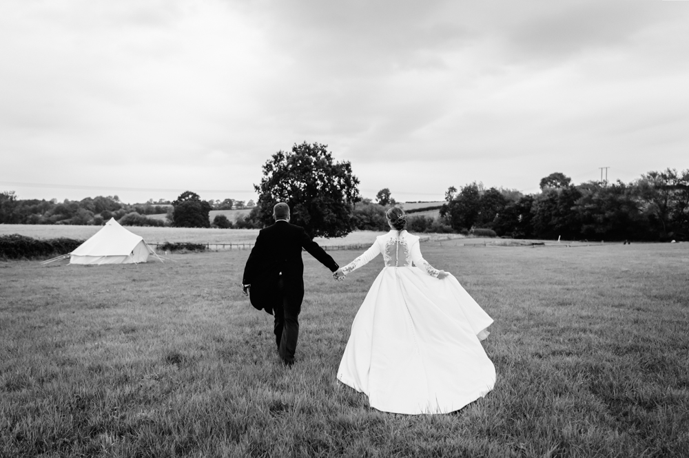 bride and groom walking in a field natural wedding photography 