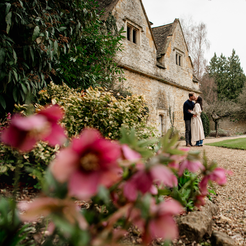 engaged couple kissing cotswolds