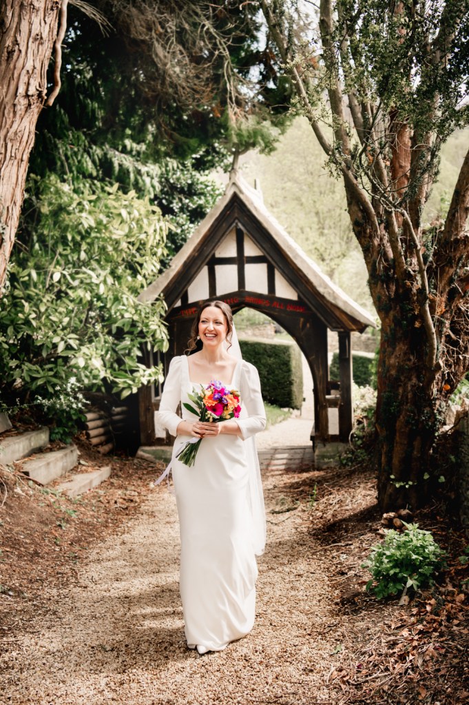 bride walking to church owlpen manor cotswolds