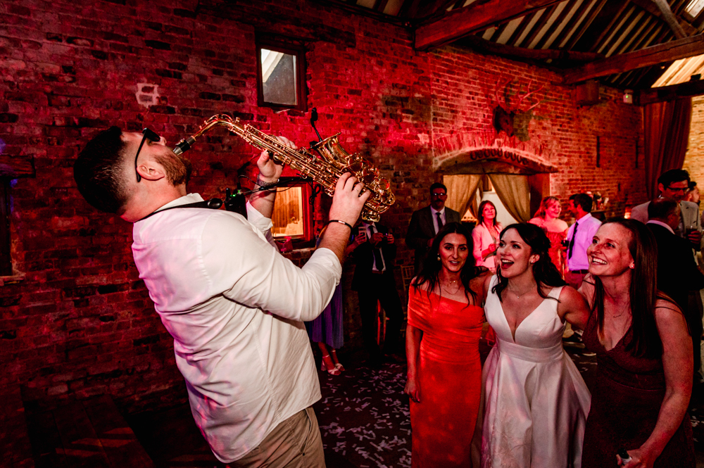 relaxed photo of bride and bridesmaids dancing to sax music 