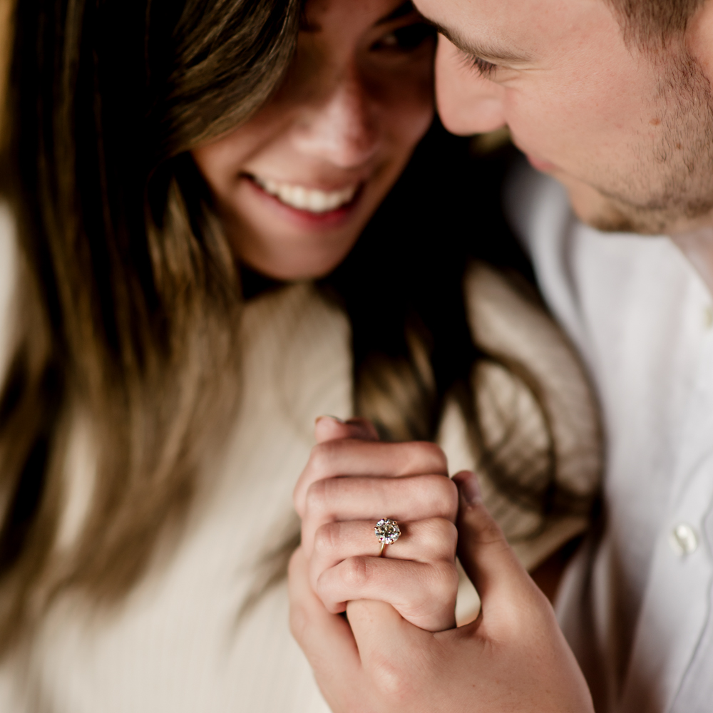 a couple holding hands and showing off engagement ring candid moment cotswolds 