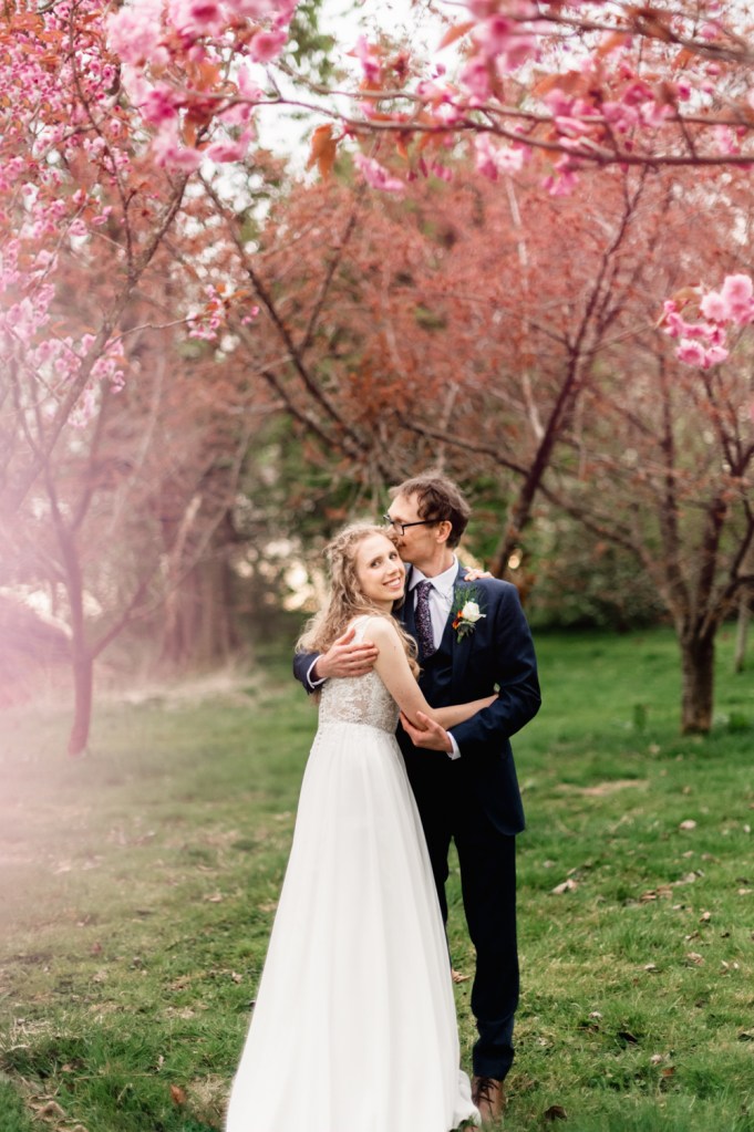 bride and groom hugging in a spring  garden at the  matara centre  cotswolds