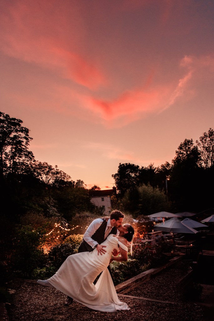 dip and kiss at sunset wedding pose