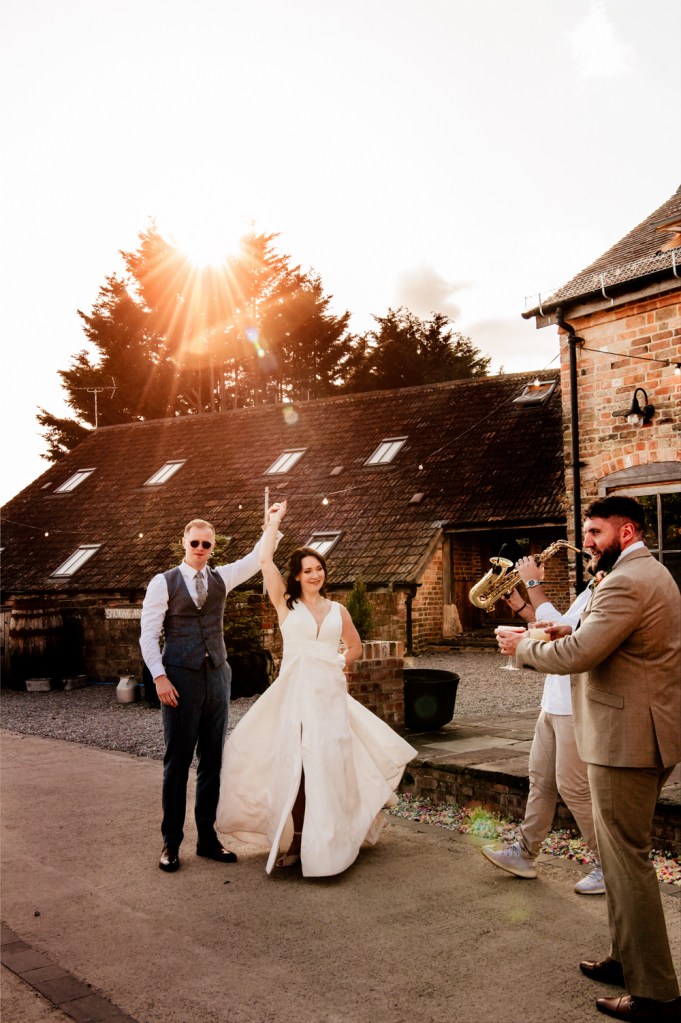 bride and groom dancing to saxophone outside at sunset dramatic wedding photography