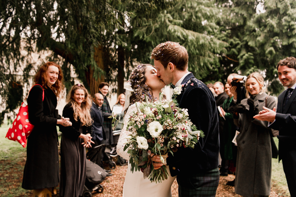 bride and groom kissing in the churchyard elmore court wedding