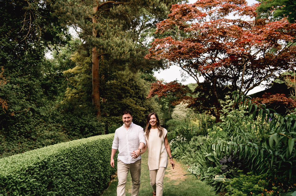 a couple walking in a beautiful garden cotswolds 