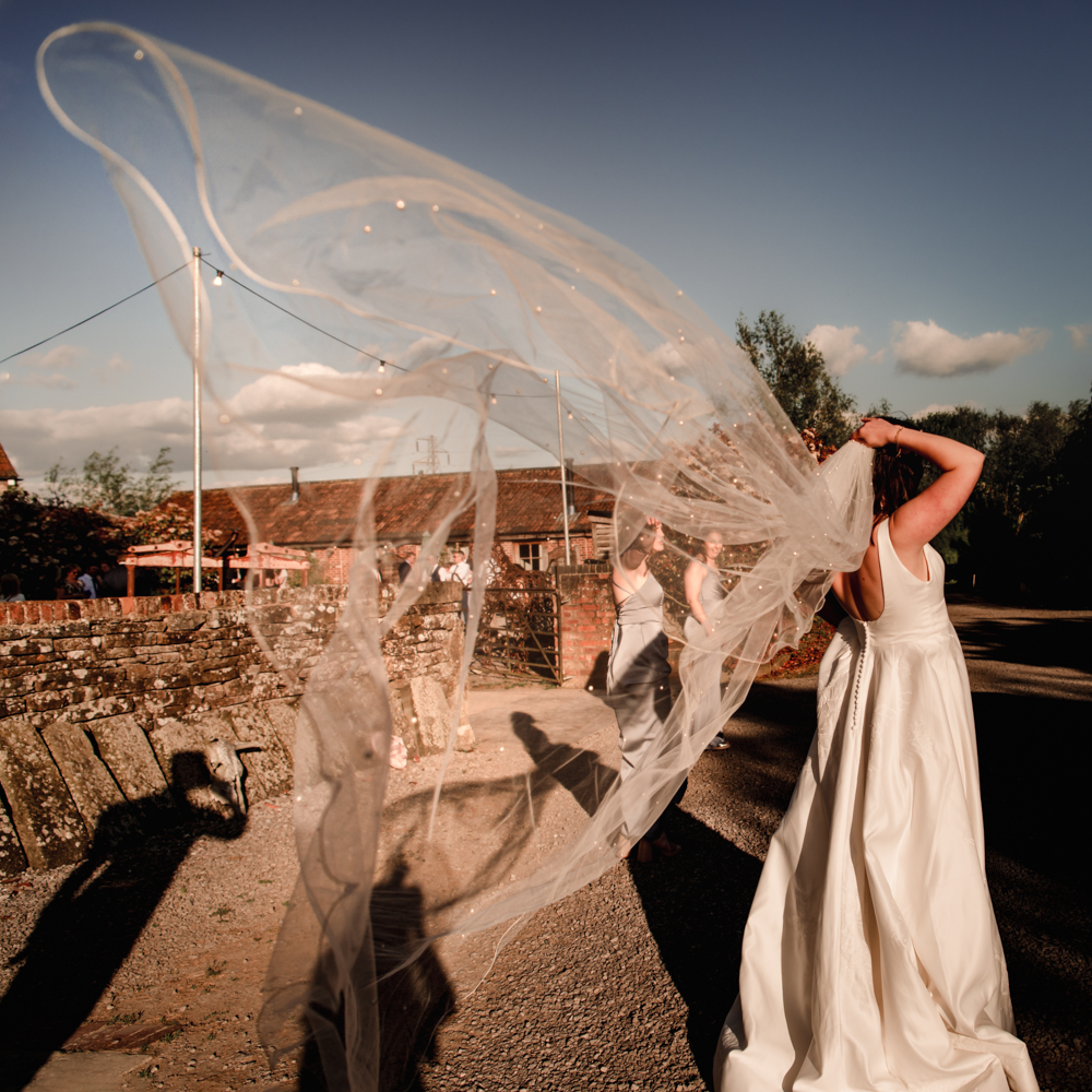 veils flying in a butterfly shape fine art dramatic wedding photography
