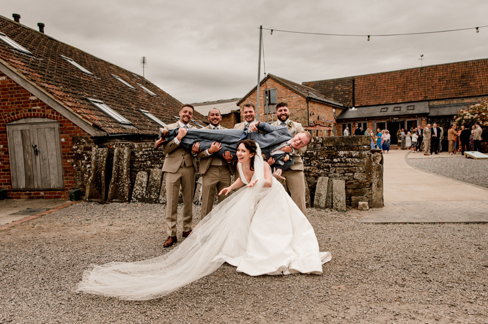 lifting the groom fun wedding  wedding photography milton end barn