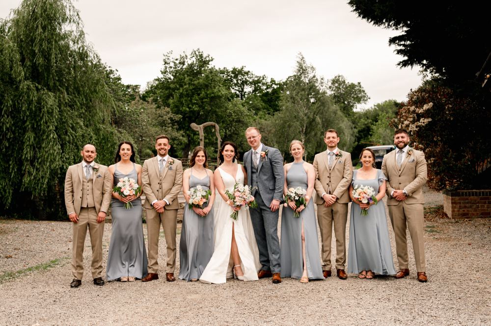 bride and groom in pastel colours modern group shot pose at milton end farm