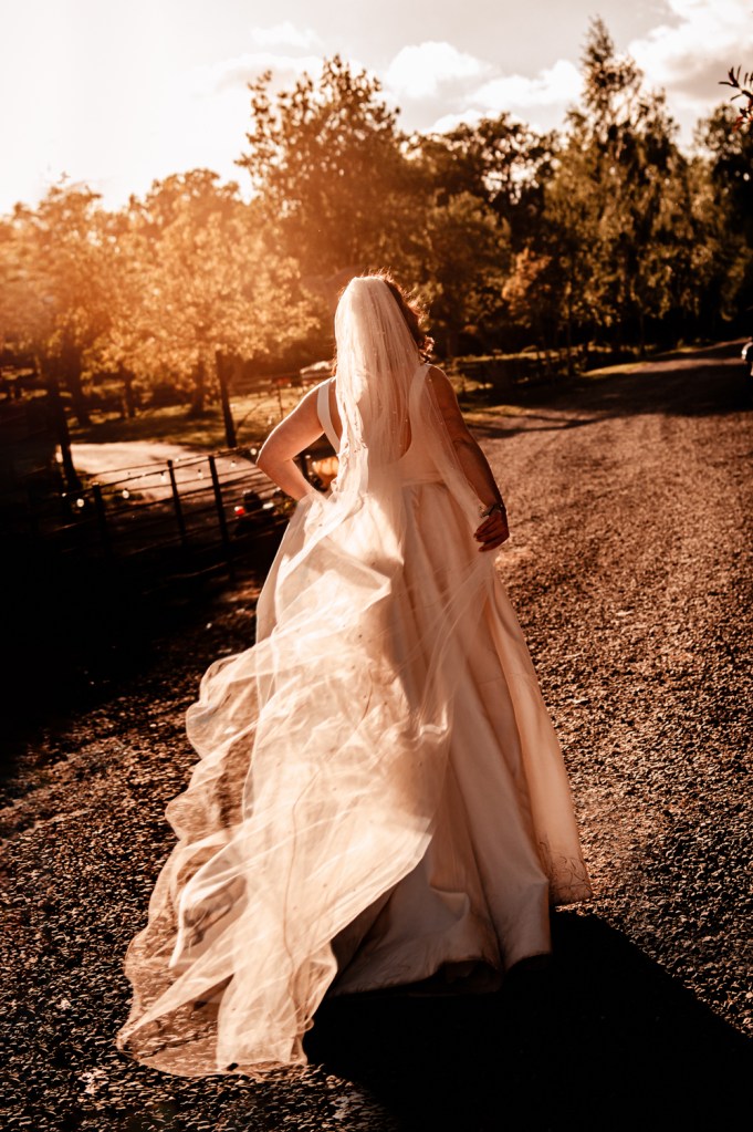 moody sunset photos of a bride walking in a dreamy landscape