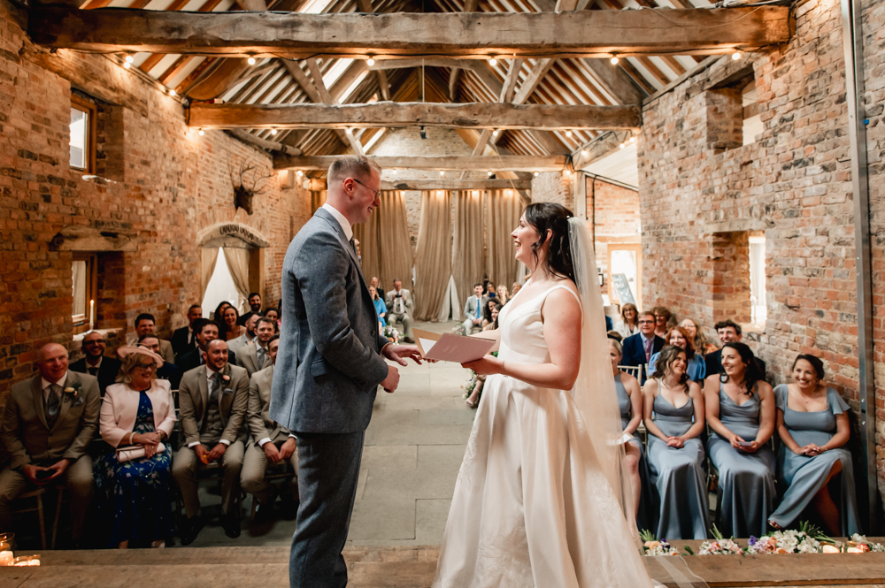 bride and groom exchanging vows  natural wedding photography at  milton end barn