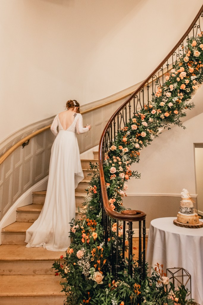 bride walking up floral staircase wedding