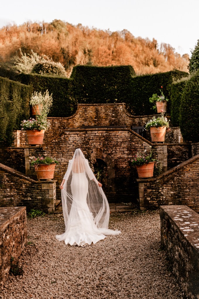bride walking in owlpen manor cotswolds