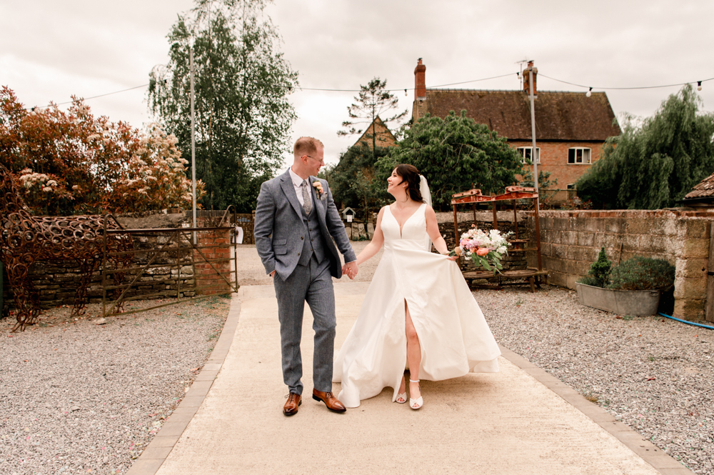 bride and groom walking in a farm soft light wedding photography