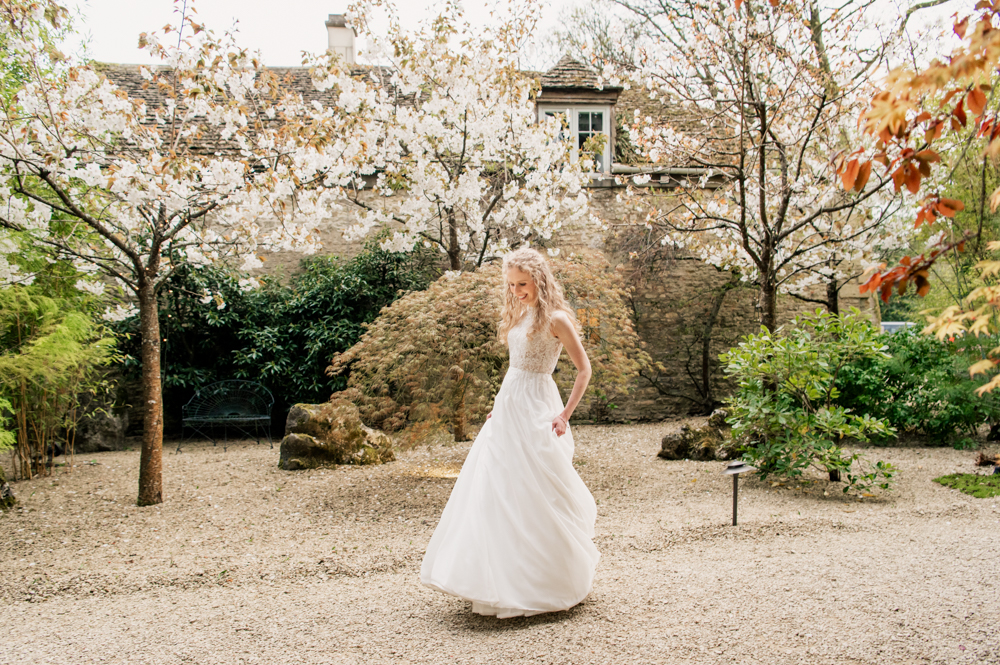 bride twirling in a spring garden cotswolds