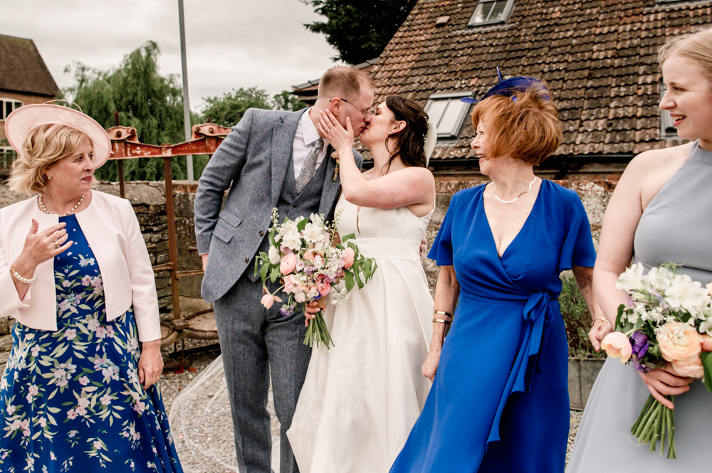 candid kissing shot at a farm wedding in the cotswolds