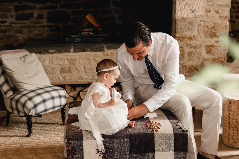 dad getting baby dressed for baptism