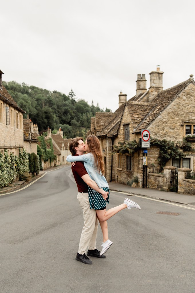 couple kissing in the middle of the quiet street cotswold village