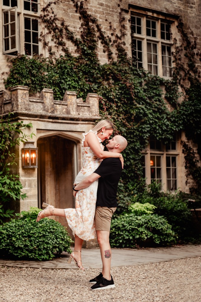 engaged couple kissing cotswolds