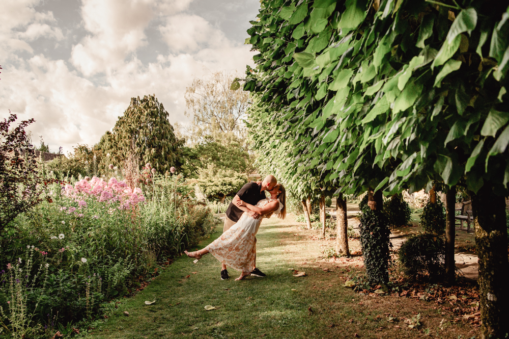 couple kissing in an english garden cotswolds