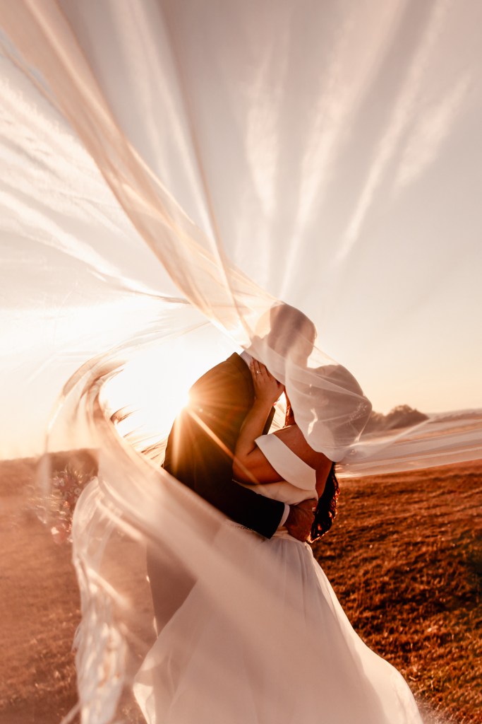 bride and groom under veil 
