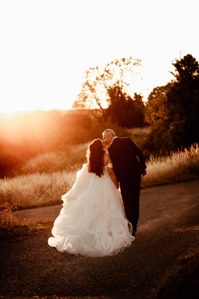 bride groom kissing sunset