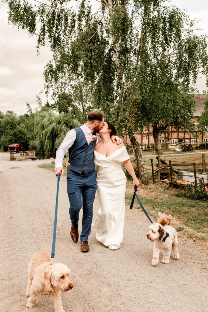 bride and groom walking with dogs countryside  wedding 