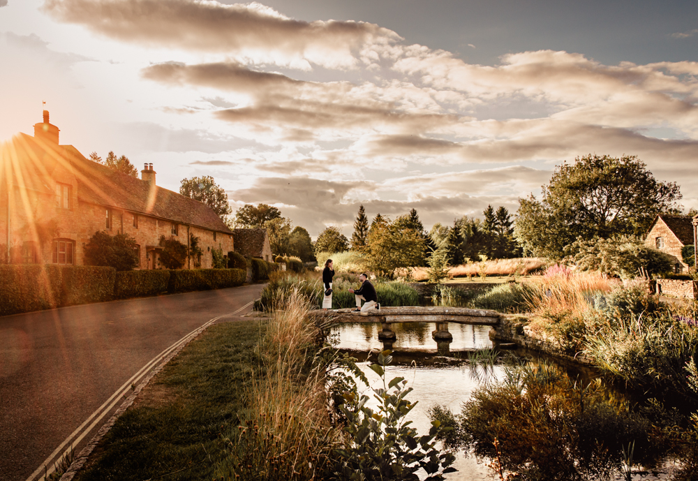 surpsrise proposal on a bridge with dramatic sunset sky