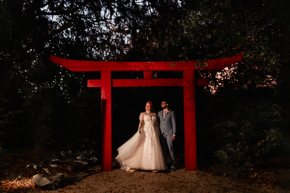 bride and groom under a tori arch