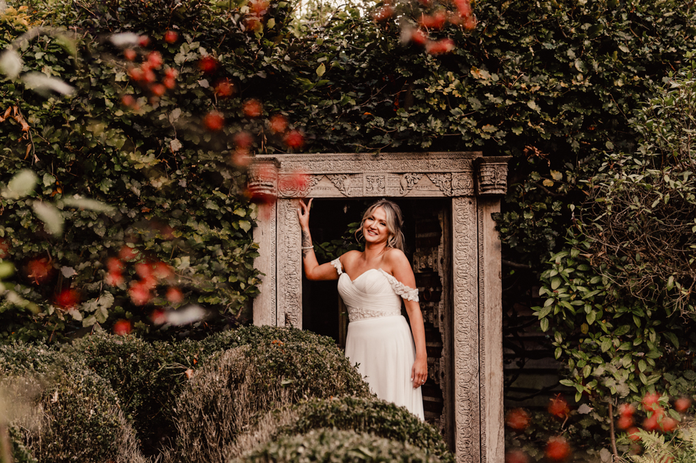 bride in a rustic wooden frame in autumn garden 