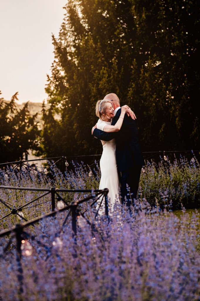 bride and groom hugging in lavender garden