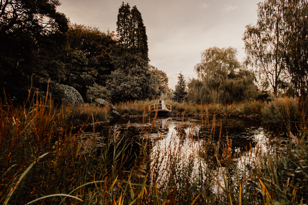 wedding by dramatic lake with bridge