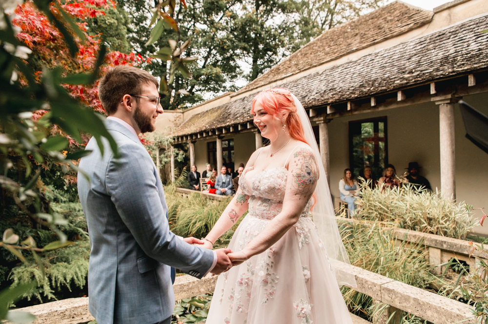 bride and groom holding hands wedding ceremony at Matara centre cotswolds