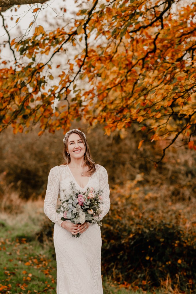 bride walking in rust coloured autumn woods