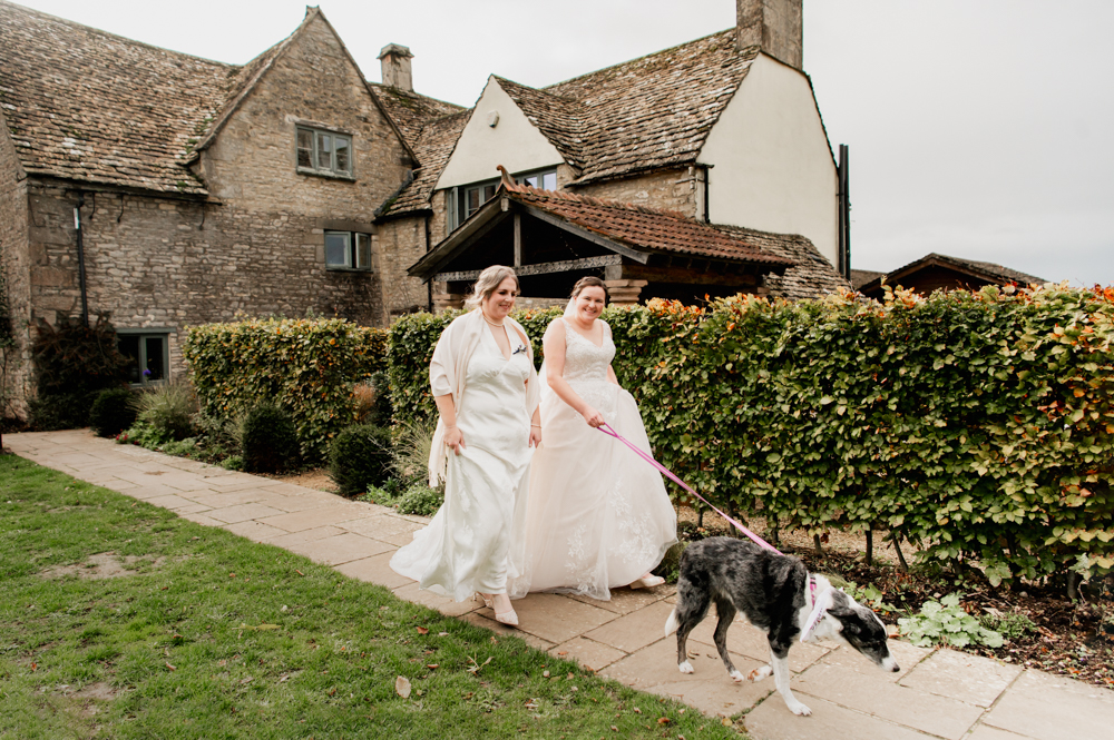 two brides walking with dog old lodge hotel wedding 