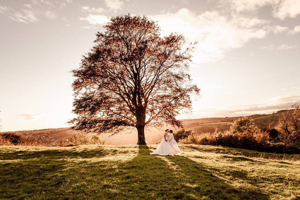 couple kissing at sunset in the cotswold countryside