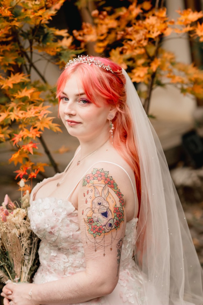 bride with pink hair in front or orange autumn tree colourful wedding cotswolds