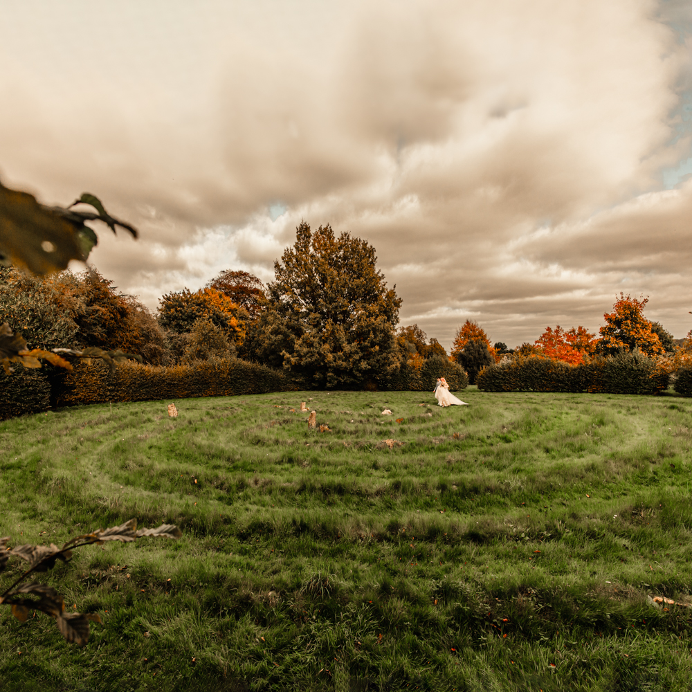 bride and groom walking on labyrinth maze at dreamy Matara centre cotswolds